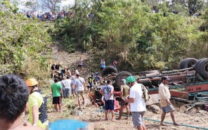 lực lượng cứu hộ và các tình nguyện viên khác đang nỗ lực tìm kiếm các thi thể bị ghim dưới gầm xe tải tại một cánh đồng mía ở Tubod. 