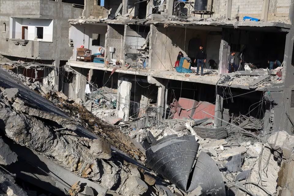 Người dân Palestine kiểm tra một ngôi nhà sau cuộc tấn công của quân đội Israel, trong bối cảnh xung đột đang diễn ra giữa Israel và nhóm Hồi giáo Palestine Hamas, ở thành phố Rafah, phía nam Dải Gaza vào ngày 22/2 - Ảnh: REUTERS/Ibraheem Abu Mustafa