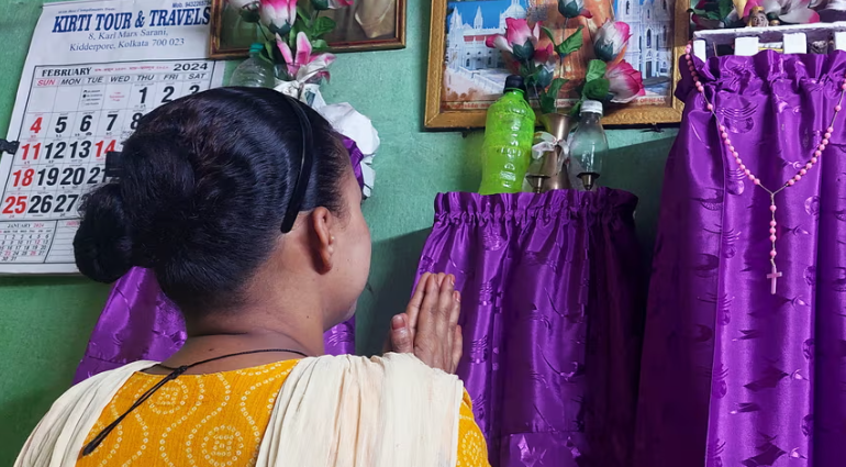 Trong ngôi nhà nhỏ một phòng ngủ mà cô ở chung với 3 thành viên khác trong gia đình ở khu ổ chuột đông đúc ở Kolkata, Lucy, hướng đến một bàn thờ tạm bợ và chắp tay cầu nguyện...