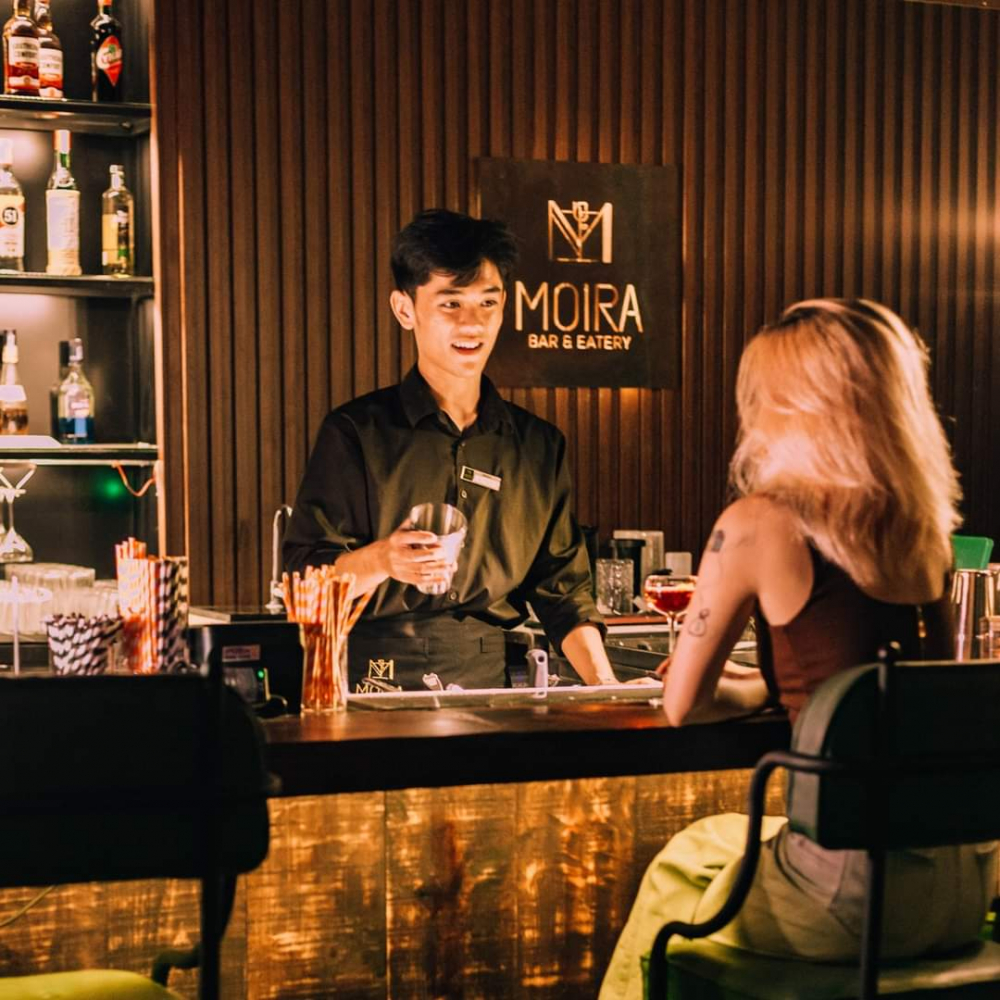 Moira Bar & Eatery được trang trí theo phong cách retro lấy tông màu xanh lá làm chủ đạo. Với cách bài trí khéo léo, hài hòa từ nội thất gỗ, kệ rượu cho đến những lớp tôn xỉn màu cũ kỹ, Moira đem đến một không gian mang đậm hơi hướng retro, cổ điển không kém phần thanh lịch, sang trọng cho những vị khách ghé qua. 