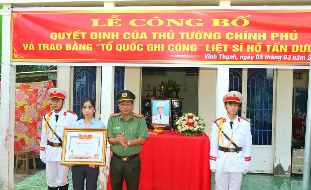 Đại tá Nguyễn Văn Hiểu, Giám đốc Công an Tỉnh trao bằng Tổ quốc ghi công cho thân nhân liệt sĩ Hồ Tấn Dương - (Ảnh: Phước Thanh)