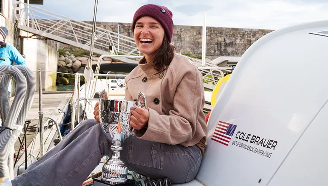 Cole Brauer tươi cười bên cạnh chiếc cúp từ ban tổ chức cuộc đua thuyền, chứng nhận cô đã một mình vượt qua hải trình vòng quanh thế giới — Ảnh: Fox News
