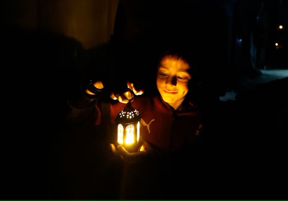 Một đứa trẻ cầm đèn lồng khi những người Palestine di tản chuẩn bị lều cho tháng Ramadan ở thành phố Rafah, phía nam Dải Gaza ngày 9/3/2024 - Ảnh: REUTERS/Mohammed Salem