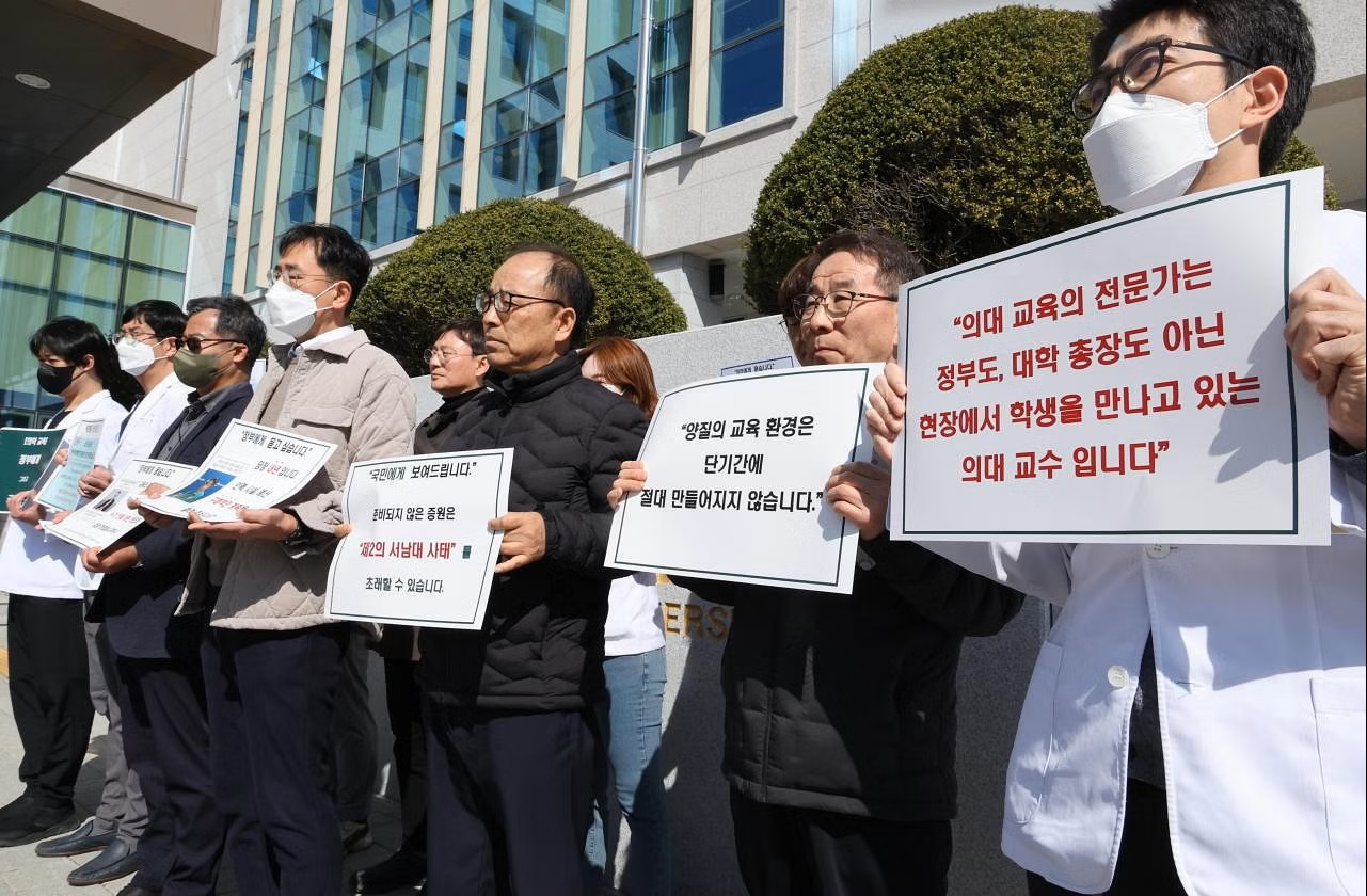 Các giáo sư y khoa Hàn Quốc giơ biển hiệu phản đối kế hoạch của chính phủ tăng cường tuyển sinh sinh viên y khoa tại Đại học Quốc gia Jeonbuk - Ảnh: EPA-EFE
