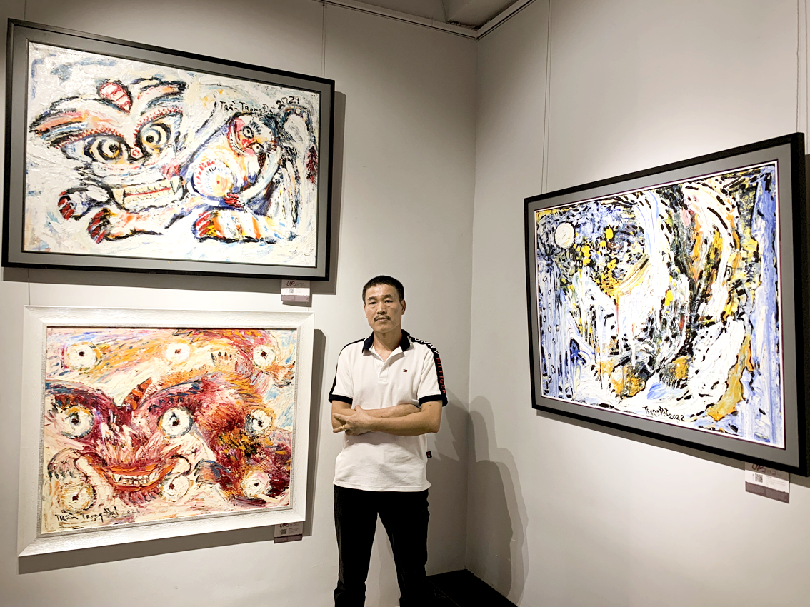 Họa sĩ Trần Trọng Đạt bên cạnh những tác phẩm của mình tại triển lãm - Ảnh nhân vật cung cấp