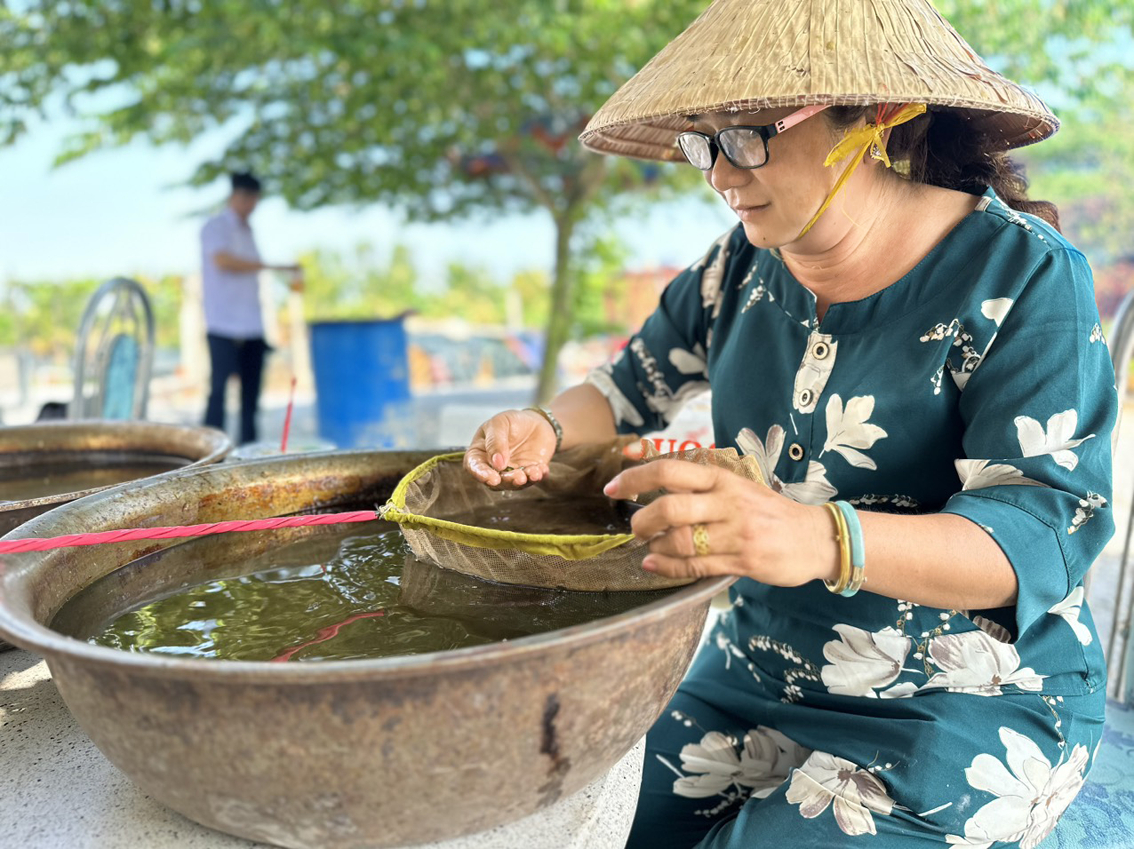 Chị Nguyễn Thị Hồng Nga đang chọn lựa cá để bán