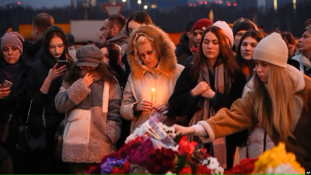 Người dân đặt hoa tại đài tưởng niệm ở ngoại ô Moscow vào cuối ngày 23/3 - Ảnh: AP