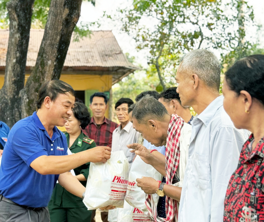 Ông Nguyễn Ngọc Sơn (bìa trái) - Thư ký tòa soạn Báo Phụ nữ TPHCM - trao quà cho bà con có hoàn cảnh khó khăn - ẢNH: TRUNG SƠN