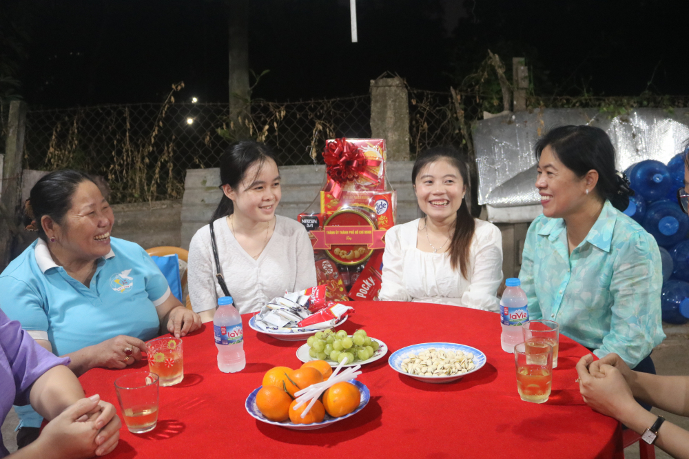 Bà Nguyễn Trần Phượng Trân (bìa phải) – Chủ tịch Hội LHPN TPHCM – hỏi thăm chuyện học tập và những trải nghiệm cùng gia đình Việt cùa 2 bạn nữ sinh viên Lào.