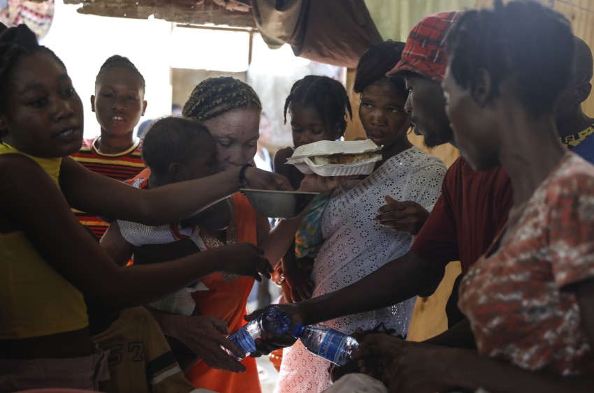 Những người phụ nữ tranh giành đĩa thức ăn cho con cái họ tại nơi tạm trú dành cho các gia đình phải di dời do bạo lực băng đảng, ở Port-au-Prince, Haiti.