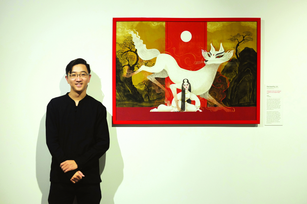 Họa sĩ Phạm Quang Phúc bên tác phẩm minh họa do anh thực hiện - Hồ Nguyệt cô hóa cáo - tại triển lãm Vẽ về hát bội