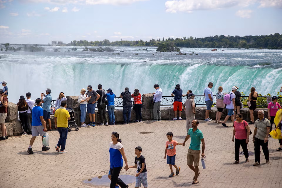 Du khách chụp ảnh trước Thác Niagara ở tỉnh Ontario, Canada vào năm 2022 - Ảnh: REUTERS/Carlos Osorio