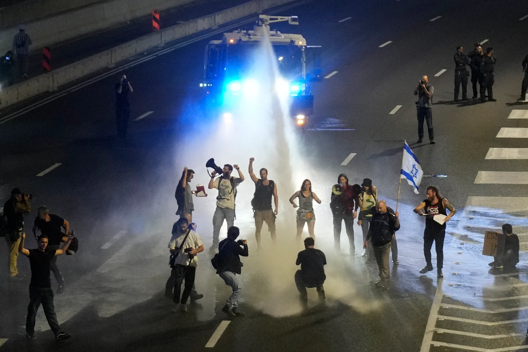 Cảnh sát dùng vòi rồng giải tán người biểu tình khỏi một đường cao tốc ở Tel Aviv vào ngày 30/3 - Ảnh: AP