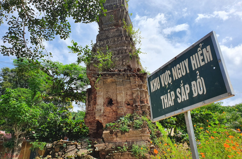 Lo sợ tháp cổ đổ sập, chính quyền địa phương phải dựng hàng rào, cắm biển cảnh báo - Ảnh: Phan Ngọc