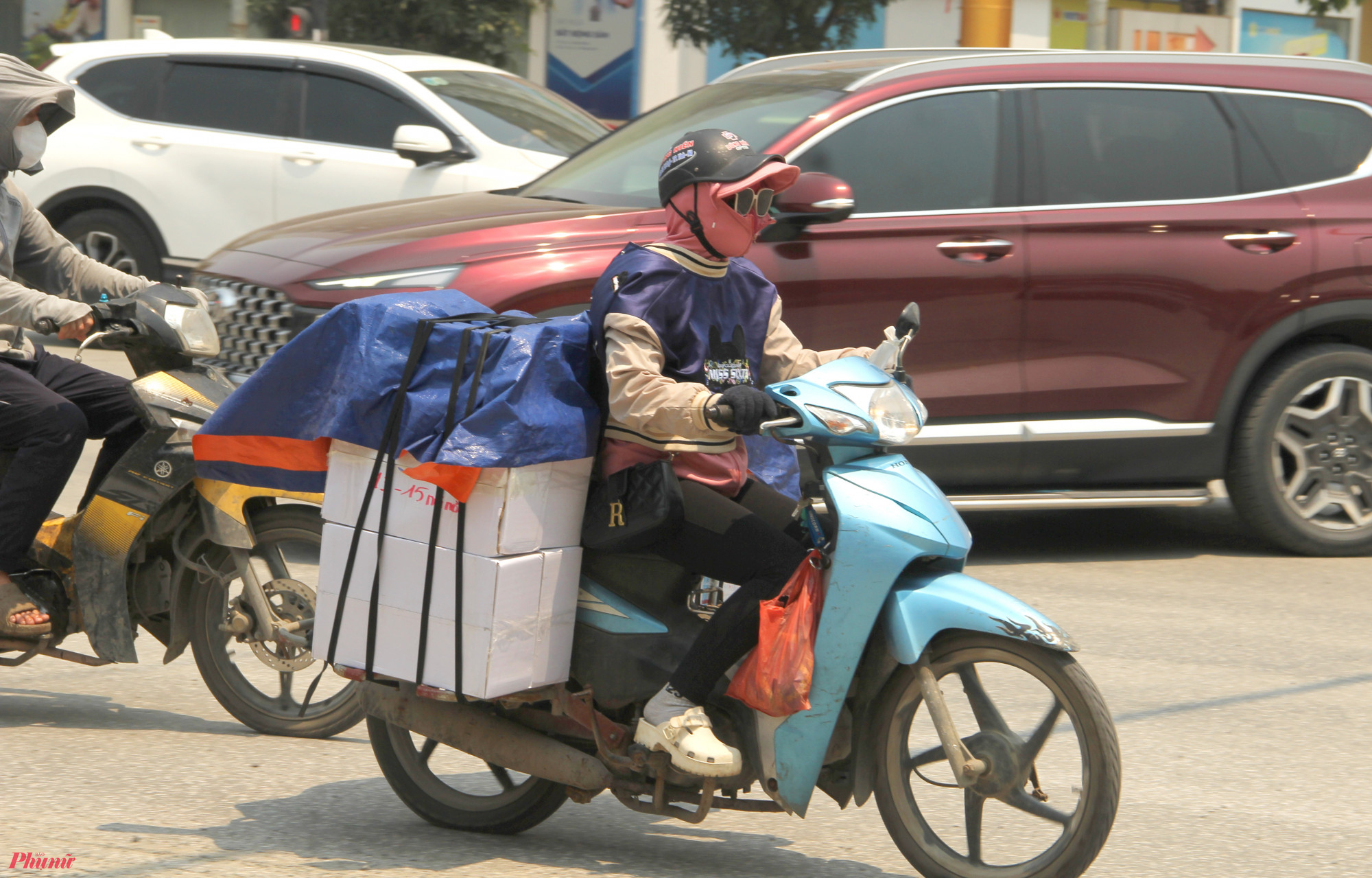 Nắng nóng kèm hiệu ứng gió phơn Tây Nam nên hai ngày qua, các tuyến phố ở TP Vinh hầu như vắng bóng người đi lại vào những giờ trưa. Những người buộc phải ra đường đều mặc quần áo chống nắng, đeo khẩu trang, kính râm kín mít từ đầu đến chân.