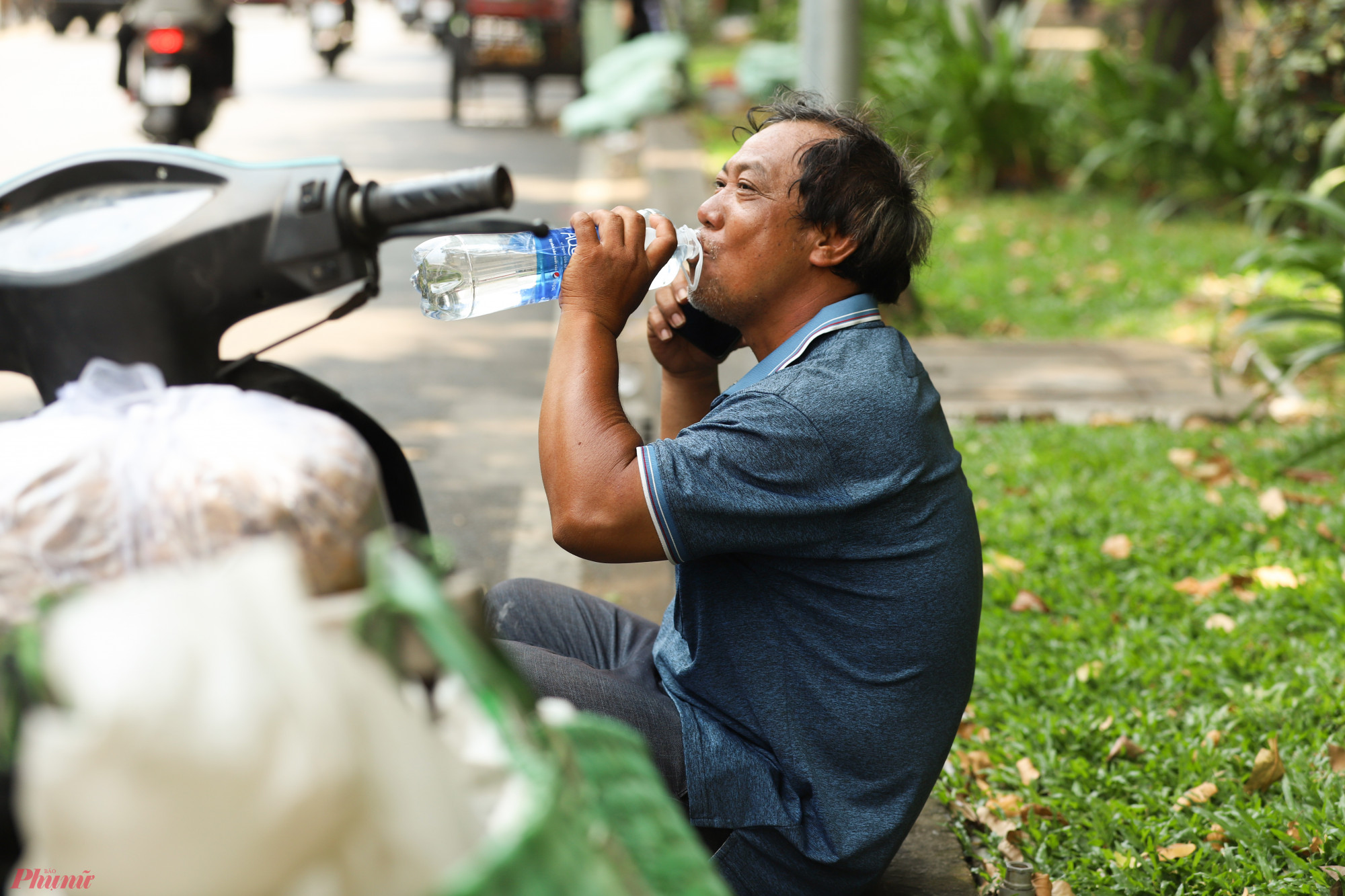 Nhiều người đi đường phải tiếp nước liên tục vì nắng nóng đổ nhiều mồ hôi gây mất nước.