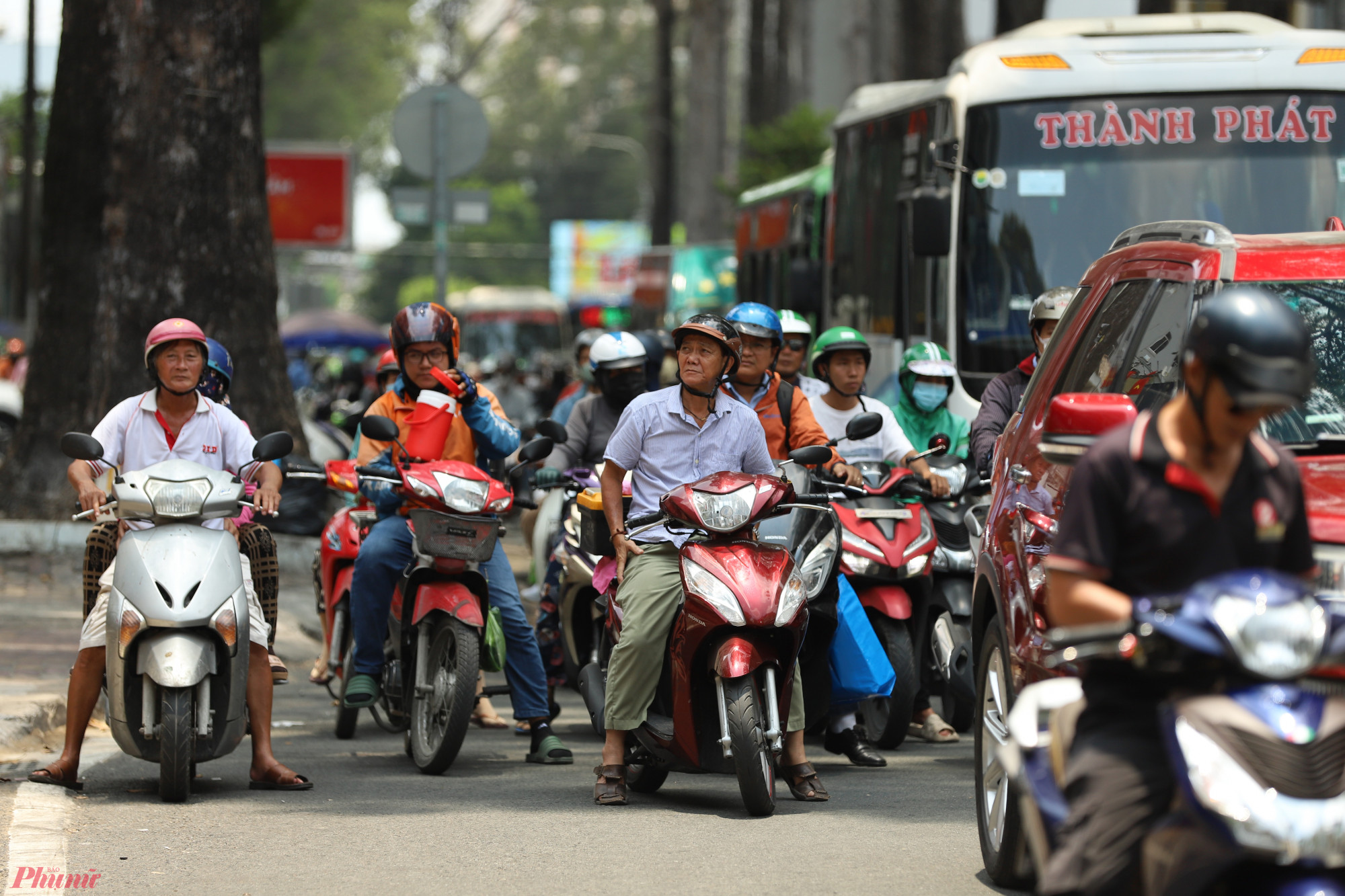 mọi người tìm nơi có bóng mát trong lúc dừng chờ đèn đỏ.