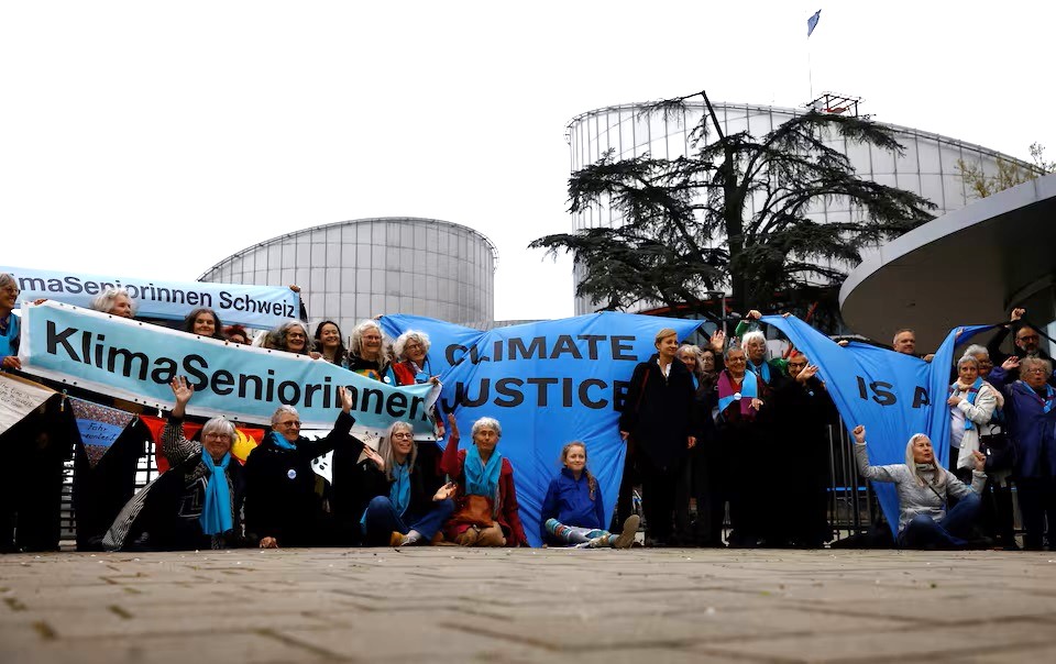 Những người ủng hộ và thành viên của tổ chức KlimaSeniorinnen cầm biểu khi họ chờ đợi phán quyết về vụ kiện khí hậu chống lại chính phủ Thụy Sĩ - Ảnh: REUTERS/Christian Hartmann