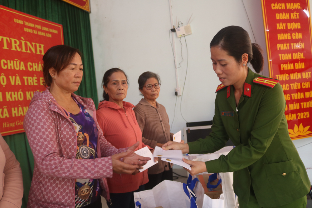 Thiếu tá Phùng Thị Thanh Phương – Chủ tịch Hội Phụ nữ Phòng Cảnh sát Phòng cháy chữa cháy và Cứu nạn cứu hộ, Công an TPHCM – trao quà  cho người dân Hàng Gòn.