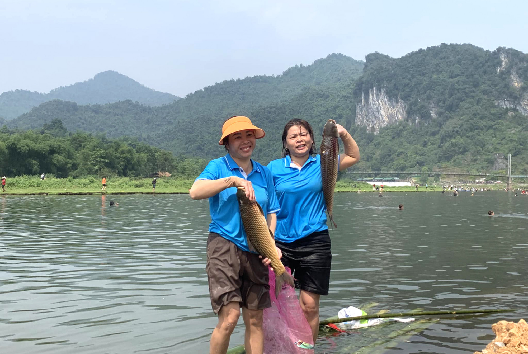 Nhiều người phụ nữ hào hứng khoe thành quả sau gần 2 giờ quăng chài bắt cá - Ảnh: Quỳnh Tây