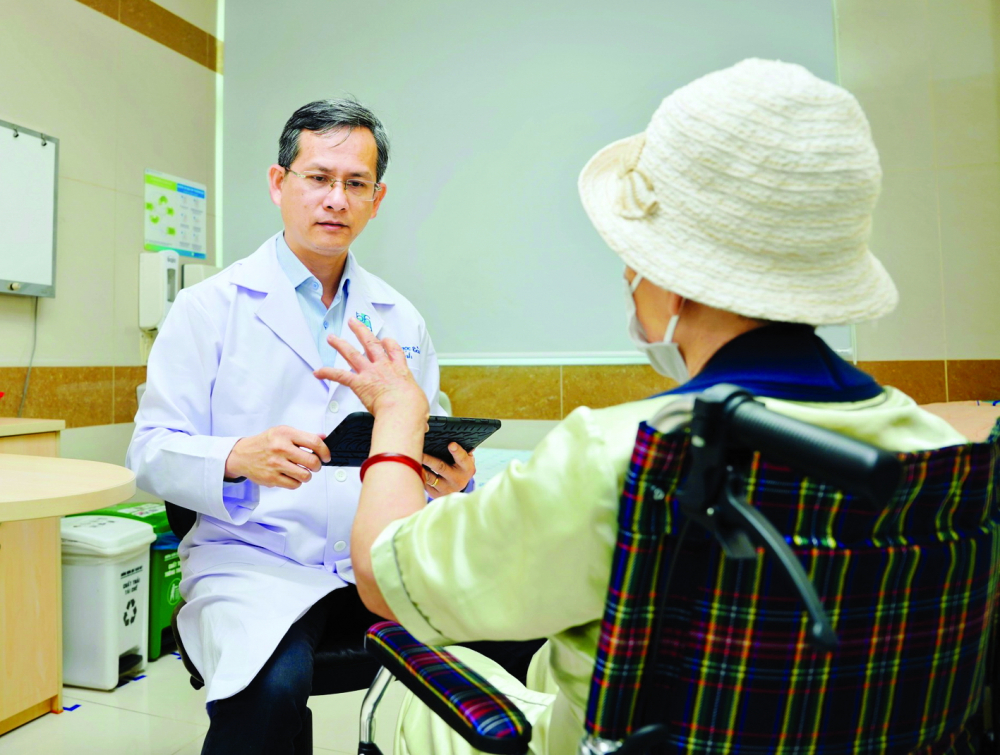 Bác sĩ Trần Ngọc Tài đang khám và tư vấn về các phương pháp điều trị phù hợp cho bệnh nhân Parkinson tại Bệnh viện Đại học y dược TPHCM - Ảnh: Đỗ Trí