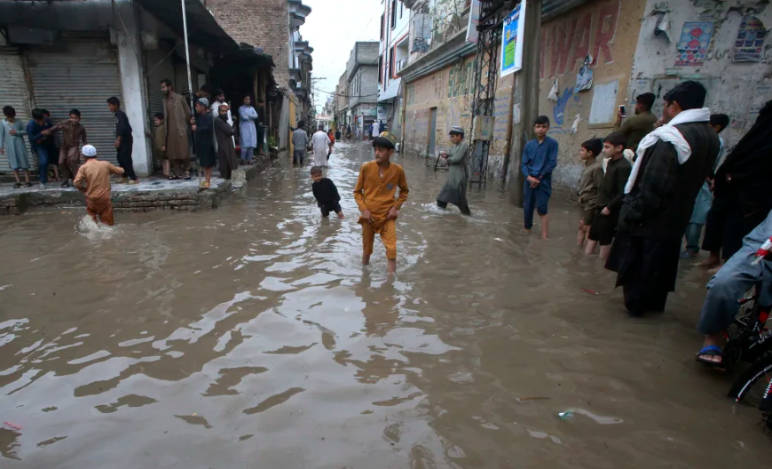 Người dân lội qua đường phố ngập lụt do mưa lớn ở Peshawar, Pakistan vào ngày 15/4/2024. Muhammad Sajjad/AP