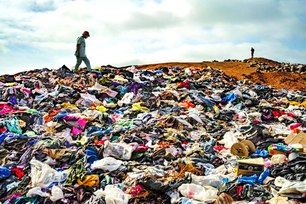 Người dân kiếm sống bằng cách lùng sục các đống quần áo ở sa mạc Atacama để tìm những món đồ có thể bán được. Mỗi tuần, nhiều lô hàng quần áo đã qua sử dụng sẽ cập cảng tại Iquique - ẢNH: TAMARA MERINO