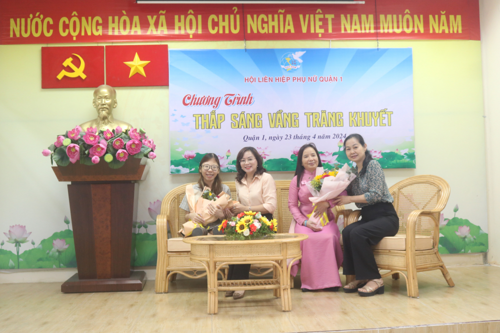 Bà Lâm Thi Ngọc Hoa (bìa phải) – Phó chủ tịch thường trực Hội LHPN TPHCM – và bà Hoàng Thị Thu Liên (thứ 2, từ trái qua) – Chủ tịch Hội LHPN quận 1 – cùng tặng hoa, động viên 2 chị khuyết tật là gương “Phụ nữ vượt khó” giao lưu với đại biểu tham dự chương trình.