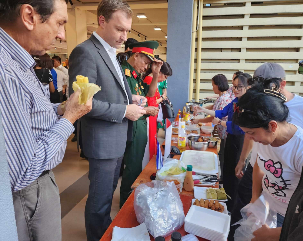 Ông Ruslan Varankou - TLS Belarus tại TPHCM (thứ 2 từ trái sang) chờ đợi thưởng thức món ăn Cuba tại buổi họp mặt