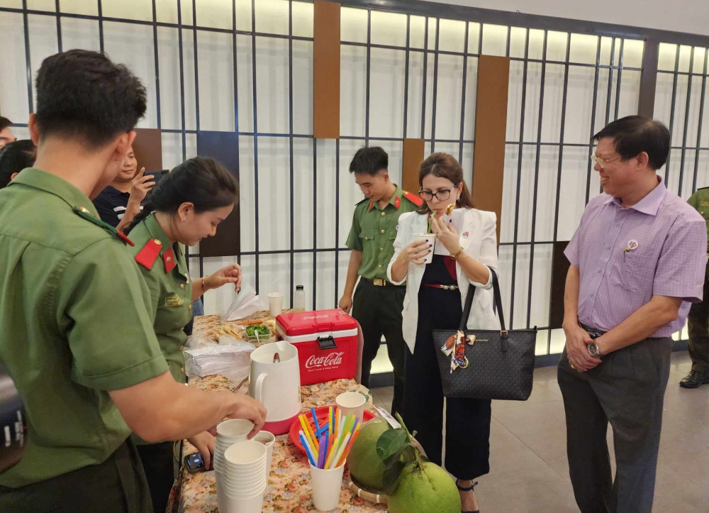 Bà Ariadne Feo Labrada nếm thử món bánh mì cùng loại nước giải khát từ dừa và bưởi được các bạn sinh viên Đại học Anh ninh Nhân dân TPHCM giới thiệu