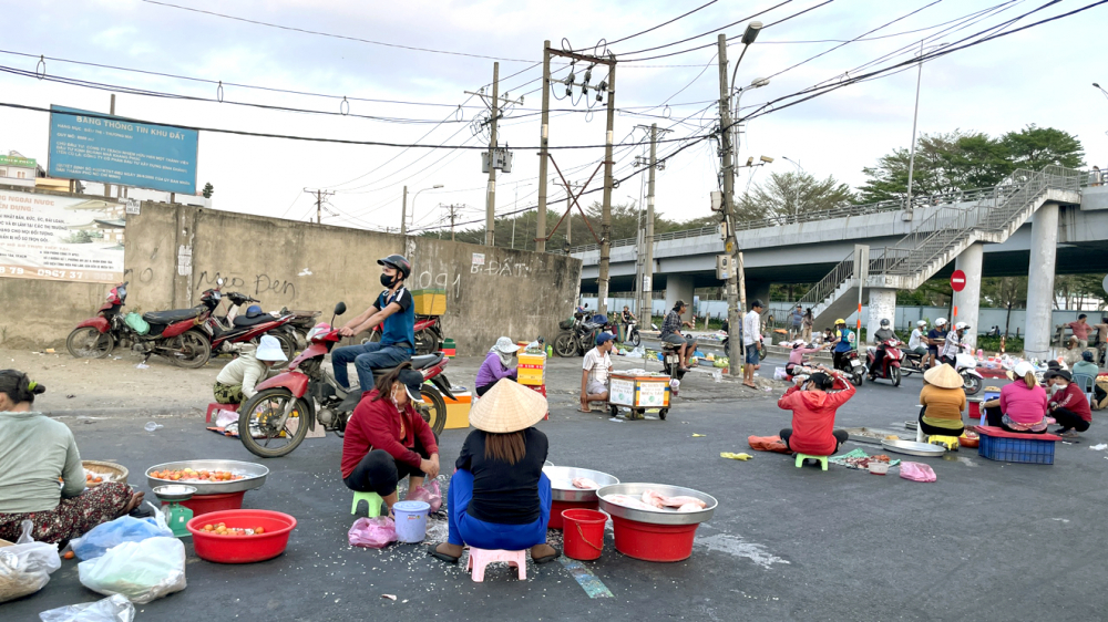 Chợ tự phát đối diện cổng Công ty TNHH Pouyuen Việt Nam (quận Bình Tân) bày thực phẩm la liệt ra đường, không bảo quản lạnh nên rất dễ ôi thiu, nhiễm khuẩn - ẢNH: TÚ NGÂN