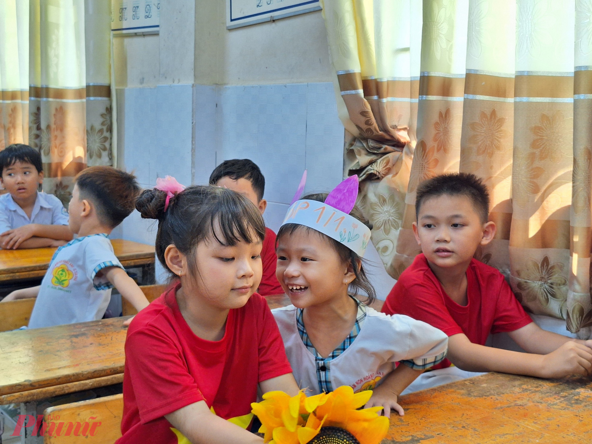 Lương Kim Linh (ở giữa) cười tít mắt, nói: “Hôm nay em rất vui khi được đi đến đây, các anh chị rất dễ thương, còn tặng vương miện cho con. Anh hai con đang học ở đây nên con cũng muốn học ở đây”.