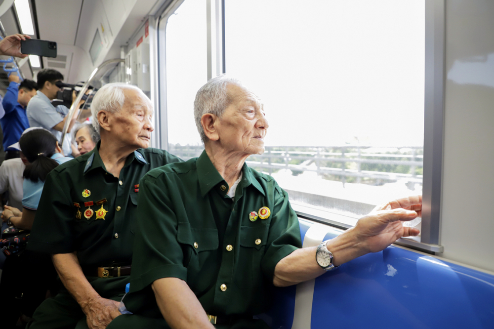 Cựu chiến binh Trịnh Hữu Cán (93 tuổi,  ngồi trước) và cựu chiến binh Dương Chí Kỳ  cảm thấy tự hào khi trải nghiệm trên tàu  metro Bến Thành - Suối Tiên - ẢNH: MINH AN