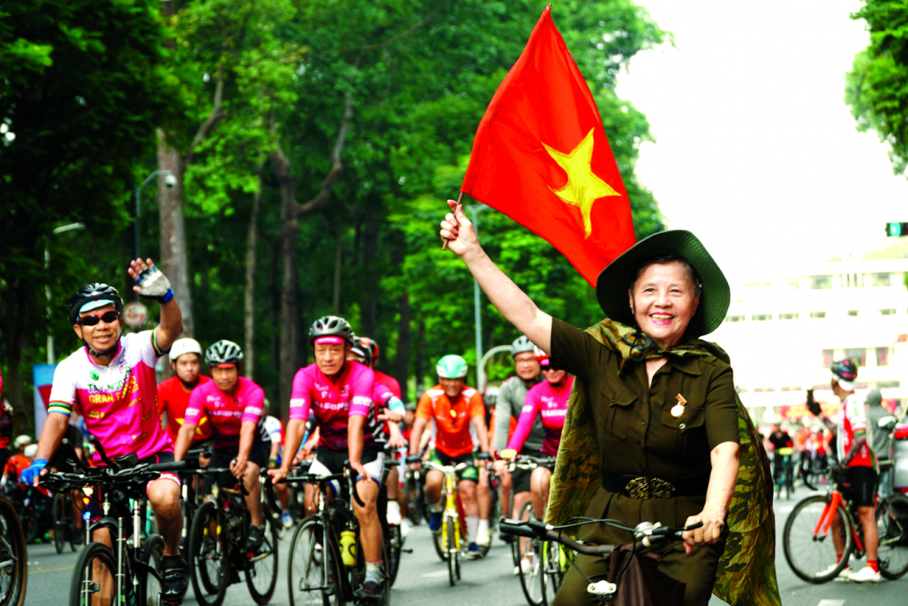 Bà Nguyễn Thị Thảo - 76 tuổi, ở phường Bến Nghé, quận 1, TPHCM - cùng hàng ngàn người dân TPHCM đạp xe  diễu hành vào ngày 30/4/2023 kỷ niệm 48 năm ngày Giải phóng miền Nam, thống nhất đất nước - ẢNH: TAM NGUYÊN