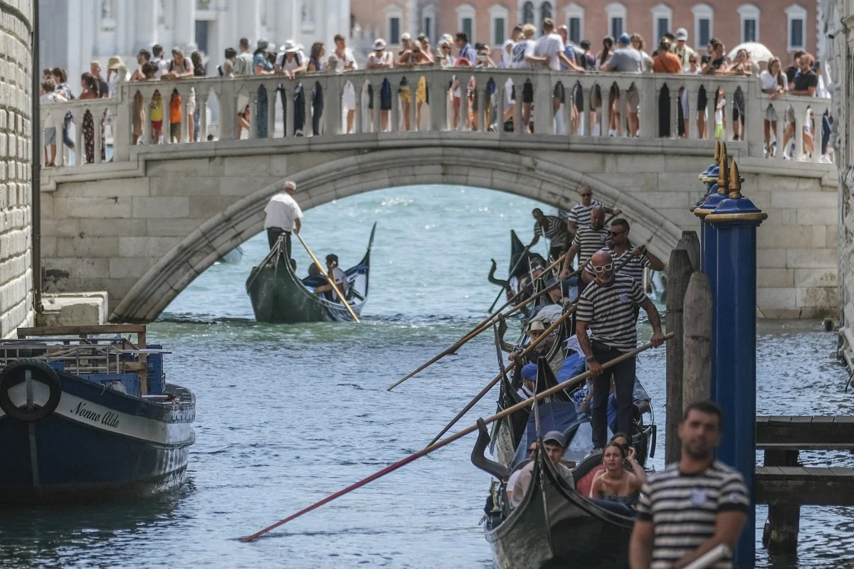 Những người chèo thuyền gondola đưa du khách băng qua Cầu Sospiri đông đúc gần Quảng trường St Mark ở Venice - Ảnh: Getty Images