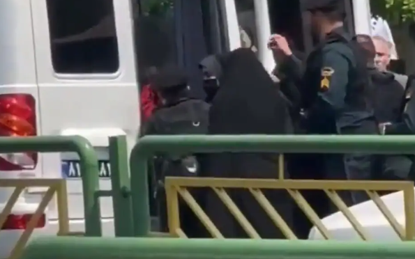 Một phụ nữ bị dồn lên một trong những chiếc xe tải màu trắng được cảnh sát đạo đức sử dụng để vây bắt những người bị cho là vi phạm quy định nghiêm ngặt về trang phục của đất nước