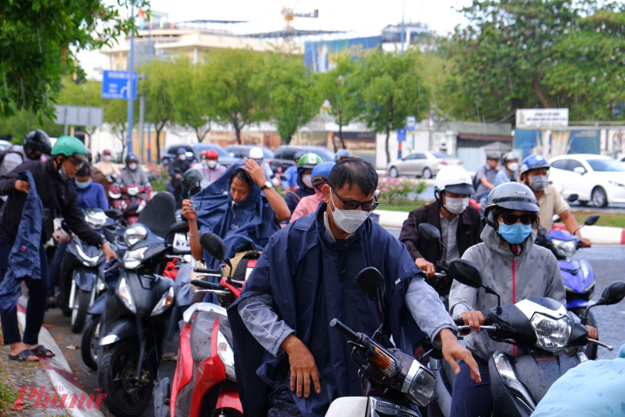 Nhiều người dân tấp xe vào đường mặc áo mưa khiến cho một số đoạn trên đường Võ Văn Kiệt ùn tắc.