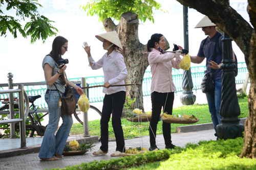 Người bán hàng rong chèo kéo khách du lịch tại khu vực Hồ Tây - Ảnh: Thanh Tùng