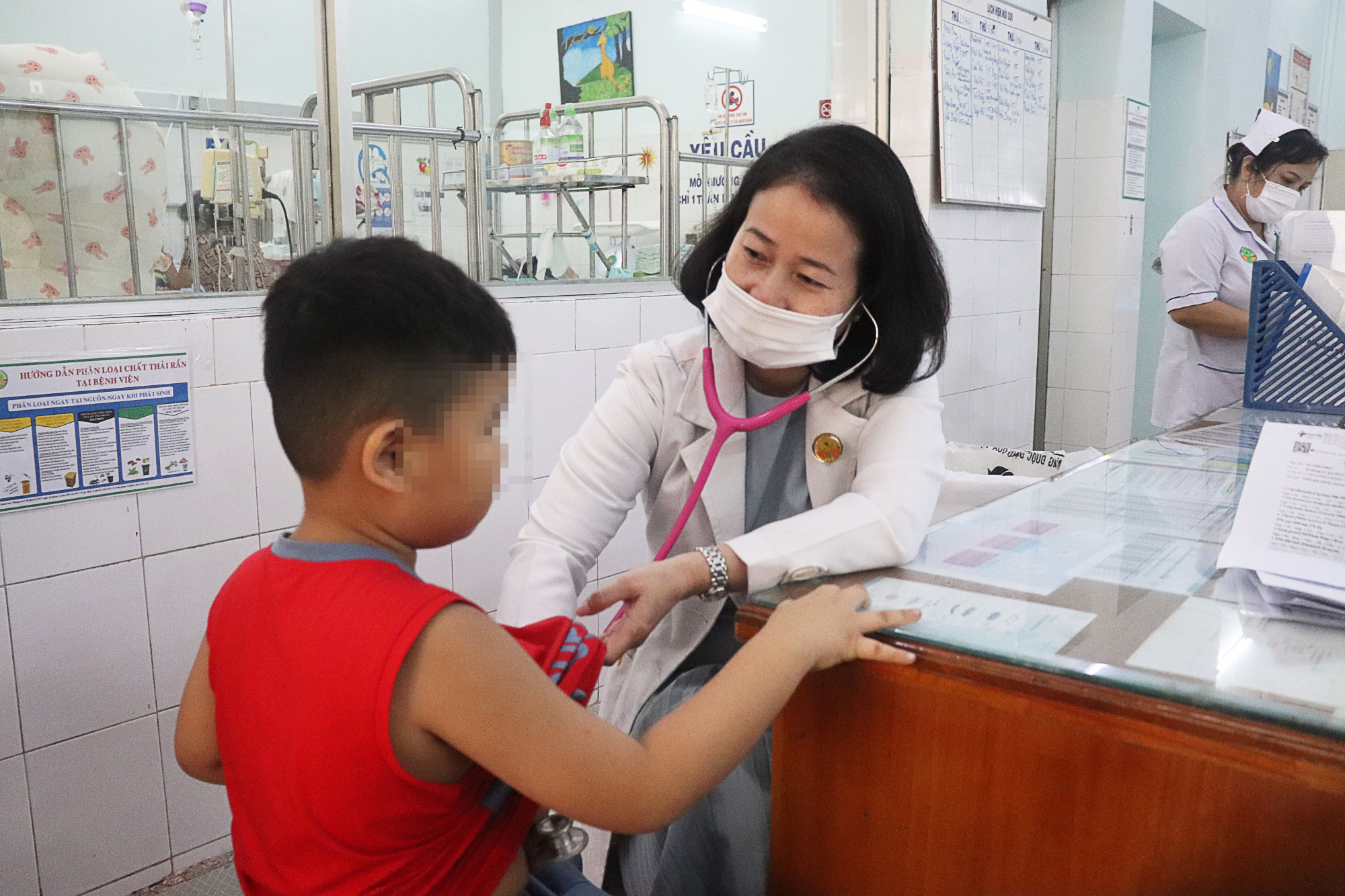 Bác sĩ Thu Thuỷ đang kiểm tra sức khoẻ cho bé M., một nạn nhân liên quan vụ ngộ độc bánh mì ở Đồng Nai (ảnh bệnh viện cung cấp)