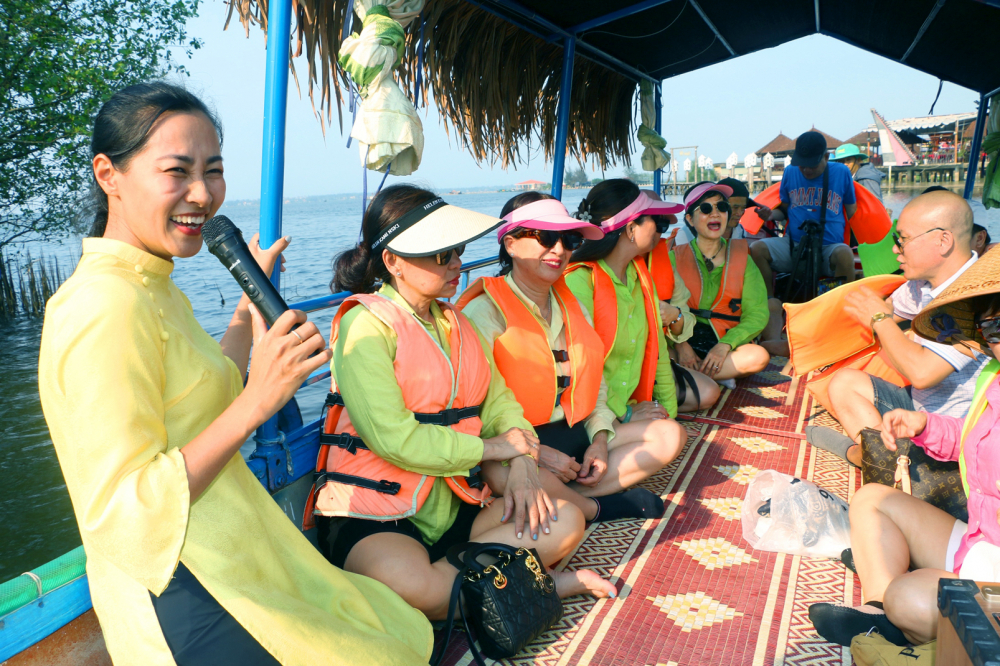 Chị Lường Thị Hiền (bìa trái) yêu thích và gắn bó với công việc hướng dẫn khách du lịch ở phá Tam Giang