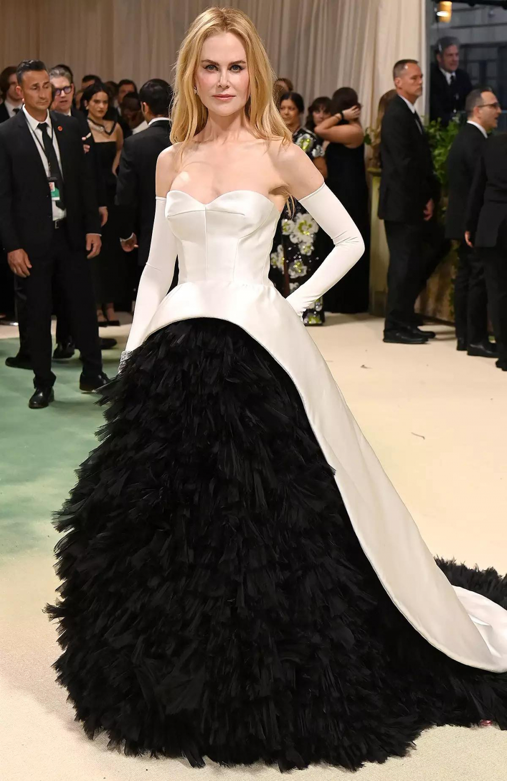 Áo choàng dạ hội Balenciaga màu ngà vừa vặn của Nicole Kidman mở ra để lộ các tầng organza đen. Cô ấy hoàn thiện vẻ ngoài với rất nhiều viên kim cương Harry Winston.