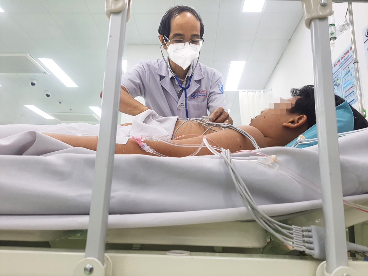 Bác sĩ Phạm Văn Quang thăm khám cho một bệnh nhi bị ngộ độc thực phẩm sau khi ăn bánh mì