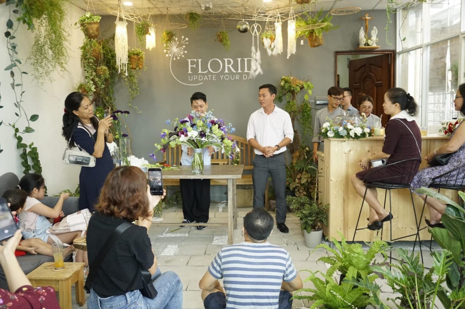 Tác giả (đứng, áo màu sáng) gửi lời tri ân bạn bè đến dự khai trương cà phê hoa Florid​ - ảnh nhân vật cung cấp