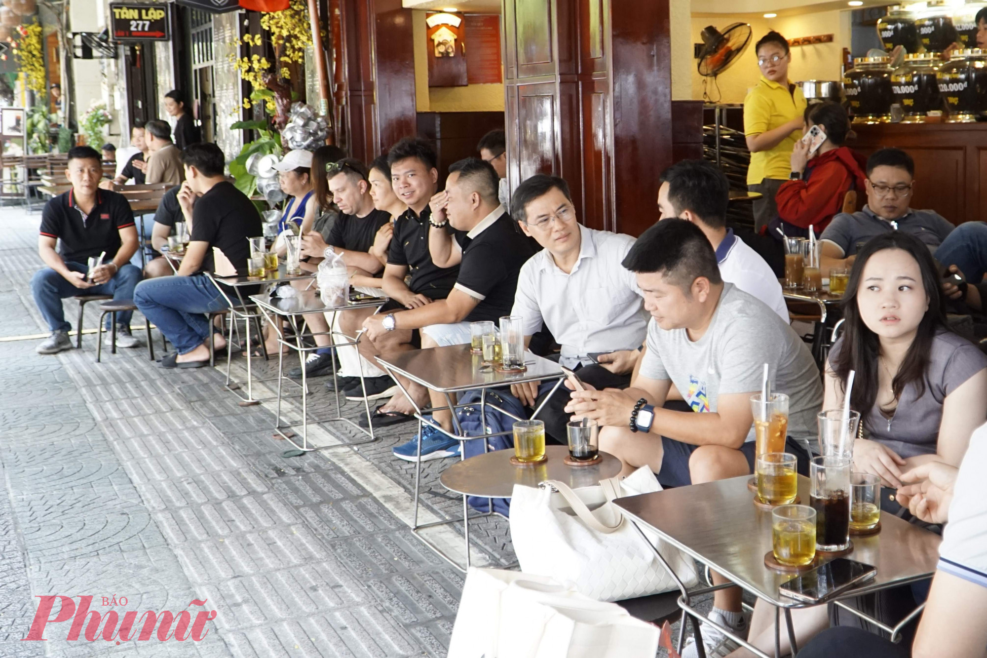Khách hàng yên tâm ngồi uống cà phê ngoài hè phố trên đường Lê Thánh Tôn, phường Bến Thành - Ảnh: Vũ Quyền