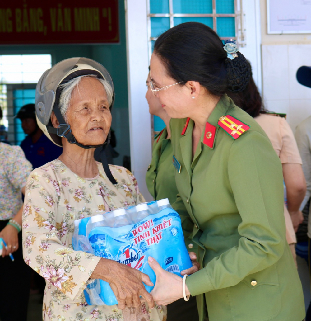 Thượng tá Nguyễn Thị Hạnh – Trưởng ban Phụ nữ Công an TPHCM –  trao tặng nước uống đóng chai cho bà con tỉnh Tiền Giang.