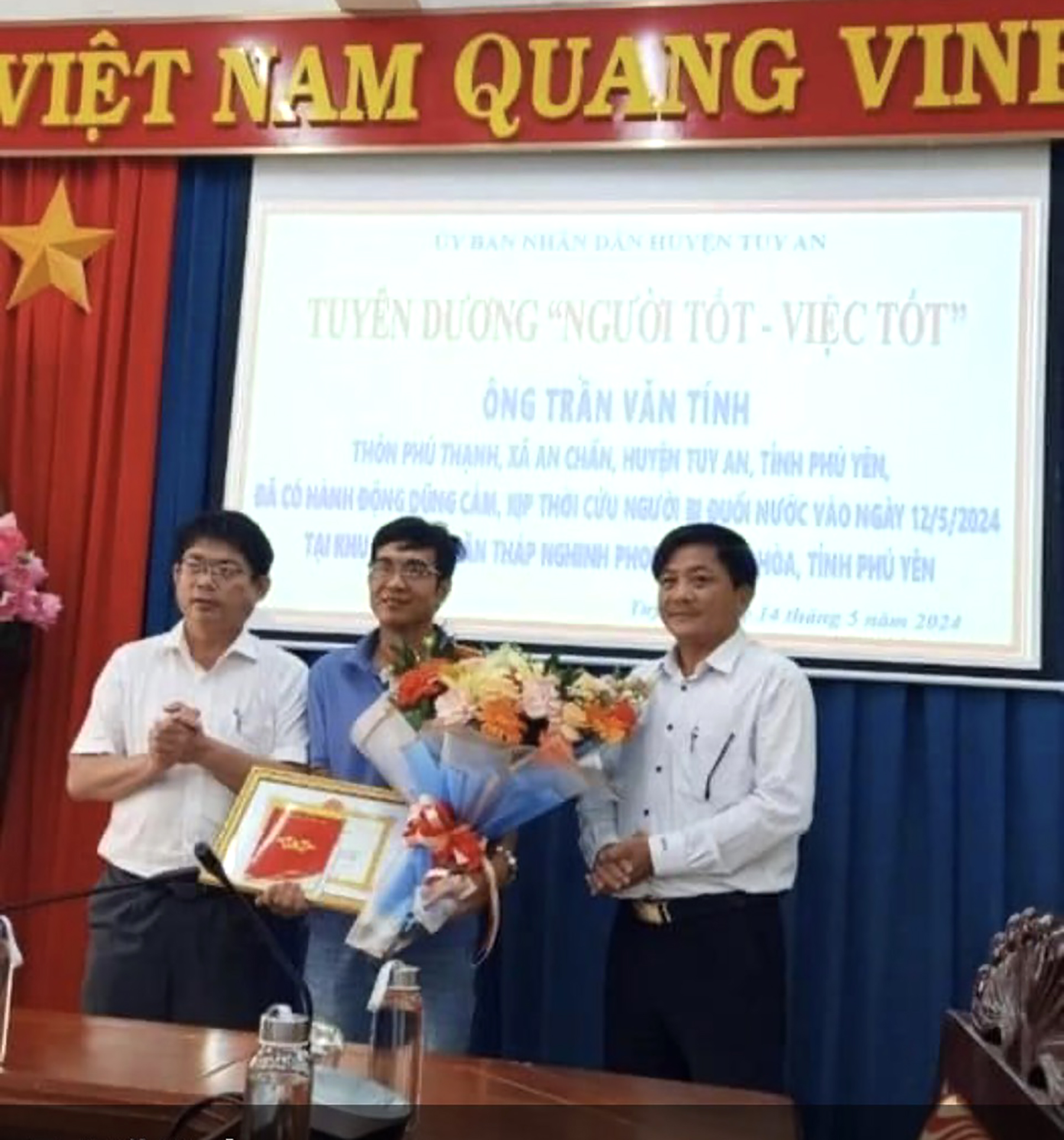 Ông Huỳnh Gia Hoàng, Chủ tịch UBND huyện Tuy An (bìa trái) trao giấy khen và tiền thưởng cho ông Trần Văn Tính (giữa).