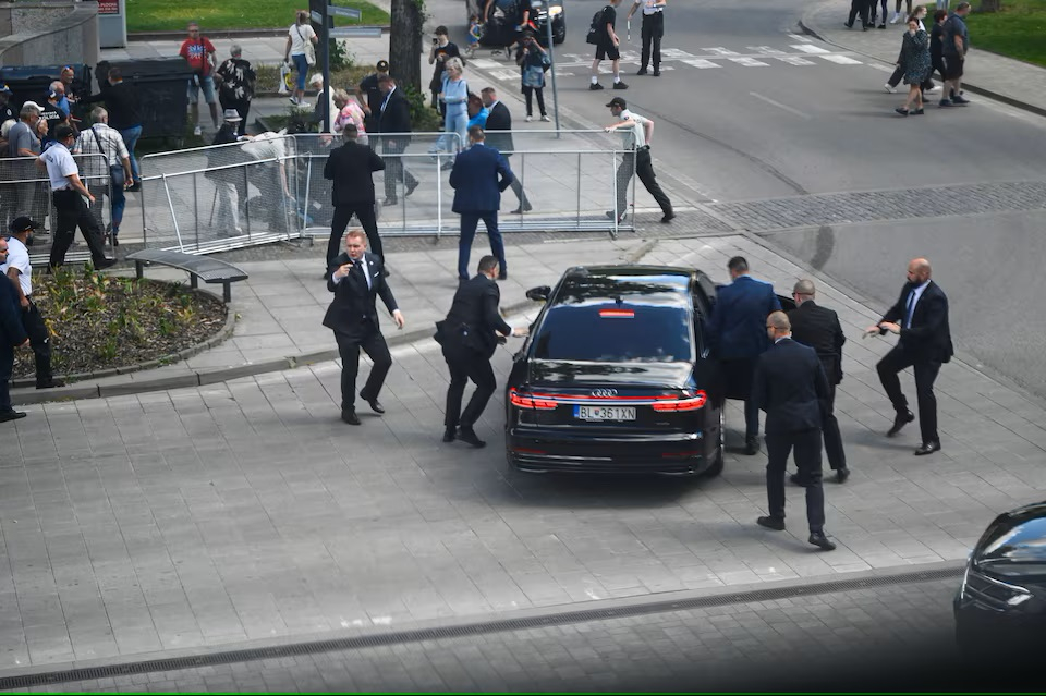 Nhân viên an ninh di chuyển Thủ tướng Slovakia Robert Fico lên ô tô sau vụ nổ súng - Ảnh: REUTERS/Radovan Stoklasa