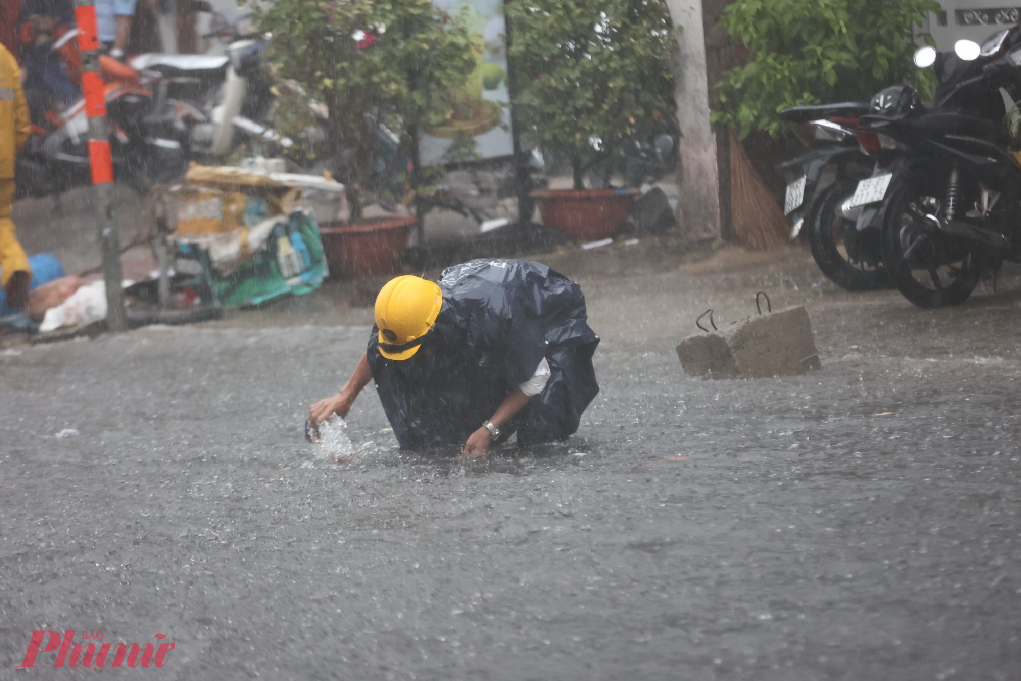 Mưa lớn cuốn rác thải bịt miệng cống thoát nước, các công nhân thoát nước phải đội mưa làm việc liên tục để khơi thông dòng chảy.