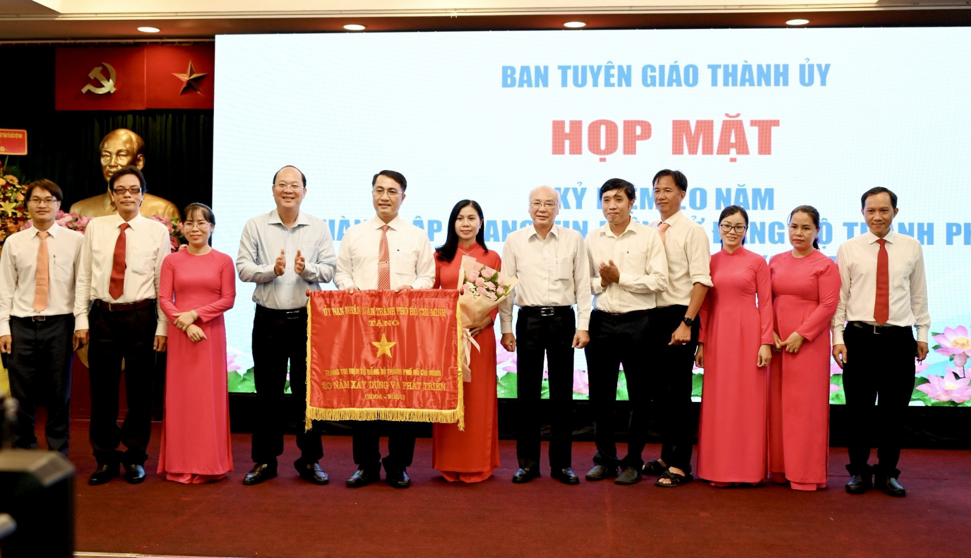 Phó Bí thư Thường trực Thành uỷ TPHCM Nguyễn Hồ Hải (áo xanh) trao tặng cờ truyền thống của UBND TPHCM đến Trang tin Đảng bộ TPHCM - Ảnh: Nguyễn Nam 