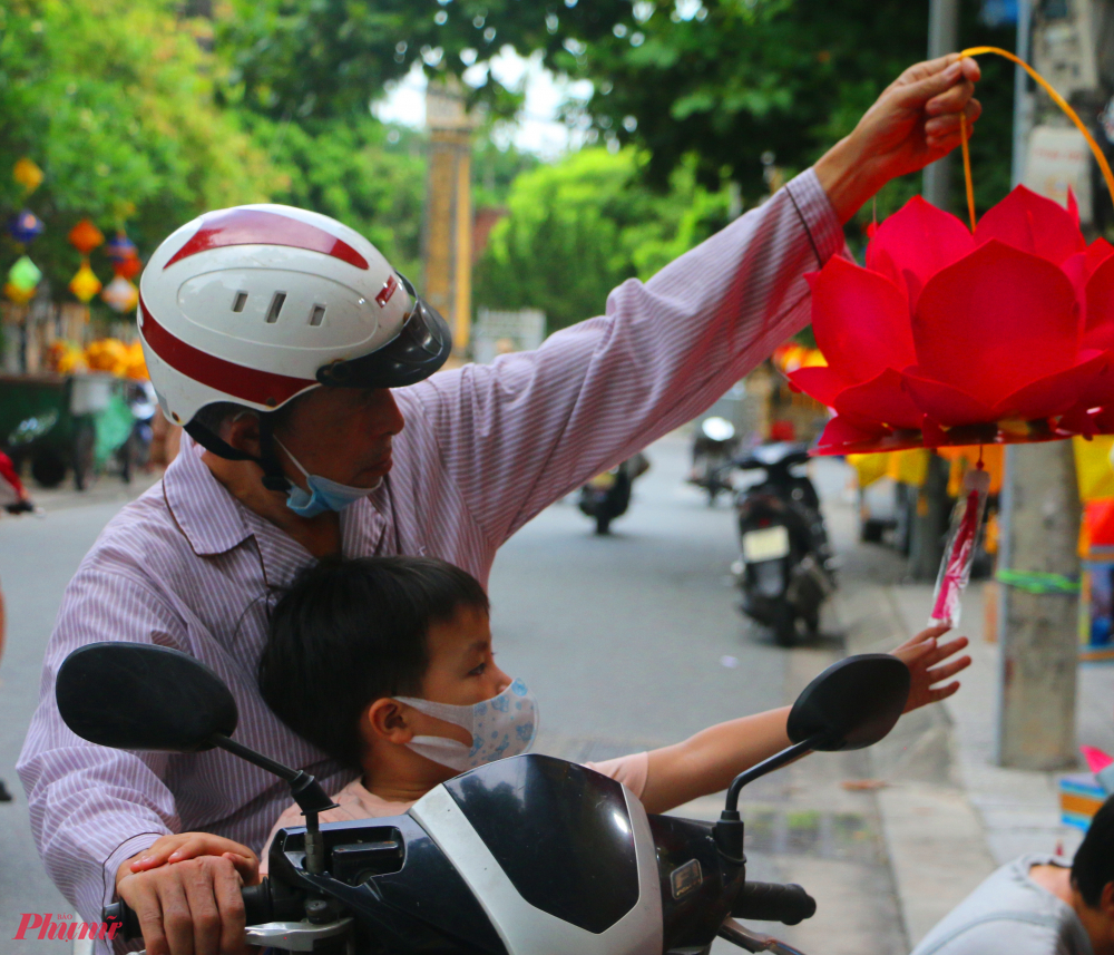 Cháu bé cùng ông nội ra phố ra phố mua lồng đèn Phật đản về nhà trang trí